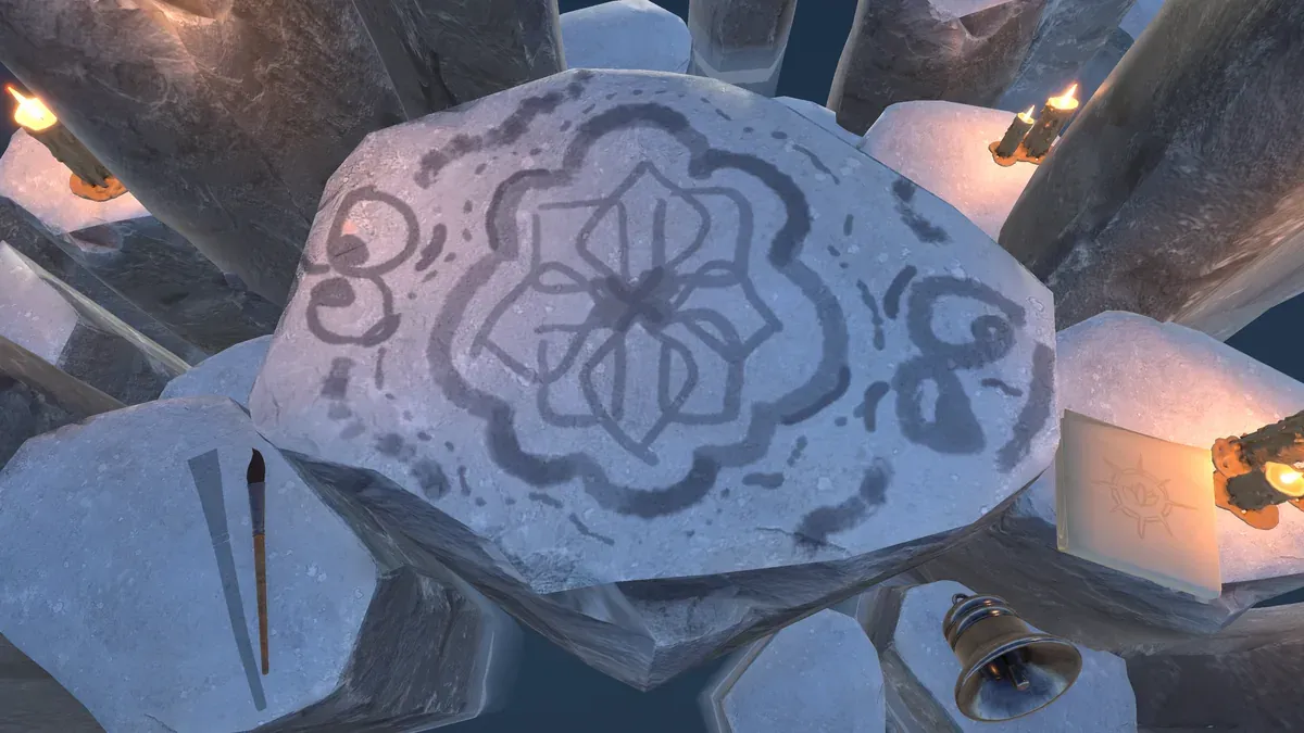A pale stone tablet ringed by candlelit rock pillars, painted in dark water-paint with a looping flower pattern and scattered strokes. A brush rests to the left, a small brass bell and a sun-marked card sit to the right.